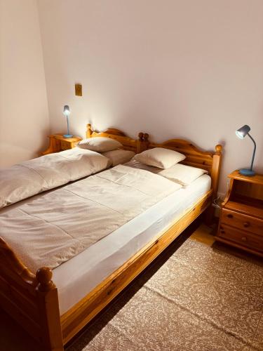 a bedroom with a wooden bed with two lamps on it at Apartment Fiemme Valley in Carano