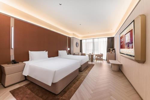 a hotel room with two beds and a table at Crystal Hotel Guangzhou Huadu in Huadu