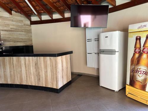 a kitchen with a counter and a refrigerator andbeer bottles at Área de lazer L&J in Barretos
