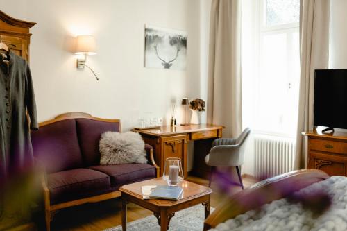 a living room with a purple couch and a table at Boutiquehotel Hubertushof in Bad Ischl