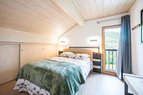 une chambre avec un lit et une grande fenêtre dans l'établissement Chalet Dolyo, à Le Fey