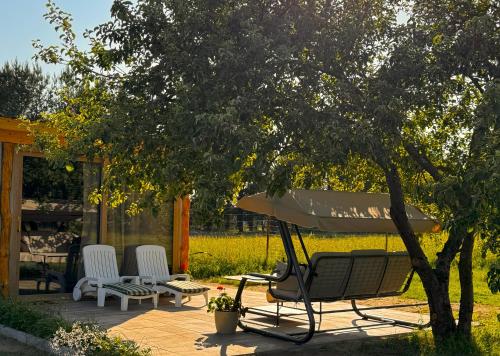 a picnic table and chairs under a tree on a patio at Pokoje Gościnne Przylesie in Łobez
