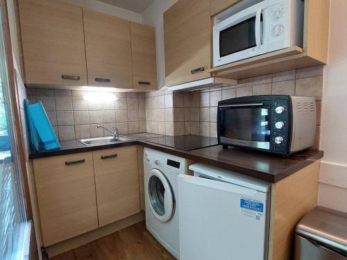 Il comprend une petite cuisine équipée d'un four micro-ondes et d'un lave-linge. dans l'établissement Studio 28m² avec balcon, couchages pour 4, Wifi et parking, proche centre-village et thermes - FR-1-512-219, à Brides-les-Bains
