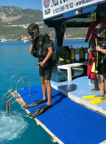 un grupo de personas de pie en un barco en el agua en Neptune Dive Club, en Kas