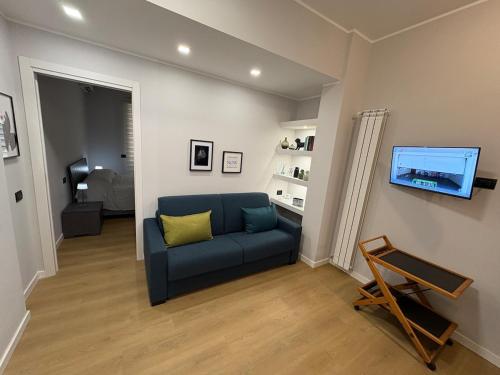 a living room with a blue couch and a tv at Masonber trastevere centro Wi-Fi free balcone metro in Rome