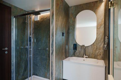 a bathroom with a shower and a sink and a mirror at L'Escale Royale Poissy Île de Migneaux - Seine in Poissy