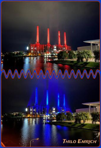 a view of a city at night with blue and red lights at Wohlfühlapartment, Parkplatz, Boxspringbetten, Massagesessel, Nespresso, 1Gbit LAN & WIFI, Innenstadt in Wolfsburg