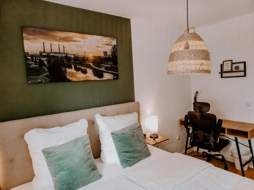 a bedroom with a bed with two pillows and a desk at Wohlfühlapartment, Parkplatz, Boxspringbetten, Massagesessel, Nespresso, 1Gbit LAN & WIFI, Innenstadt in Wolfsburg