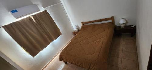 a small bedroom with a bed and a window at Mi Casita in Colón