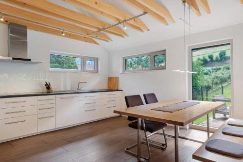 a kitchen with white cabinets and a wooden table at Müllerjörgenhof in Gutach