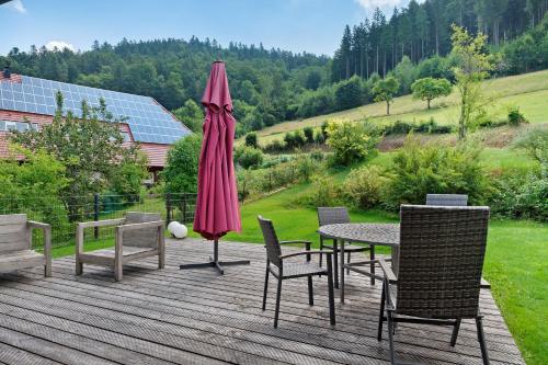 a patio with a table and chairs and an umbrella at Müllerjörgenhof in Gutach
