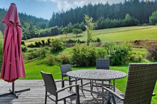 a patio with a table and chairs and an umbrella at Müllerjörgenhof in Gutach
