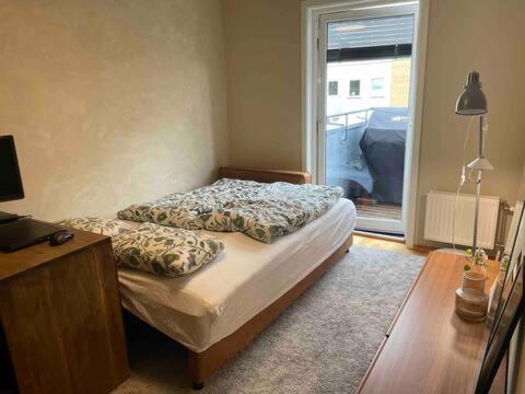 a bedroom with a bed and a desk and a window at Two bedroom apt near Oslo City Center, Norway in Oslo