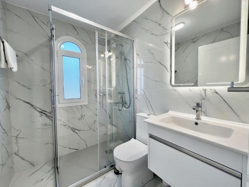 STAY Cavo Bay Villa في بروتاراس: حمام مع مرحاض ومغسلة ودش