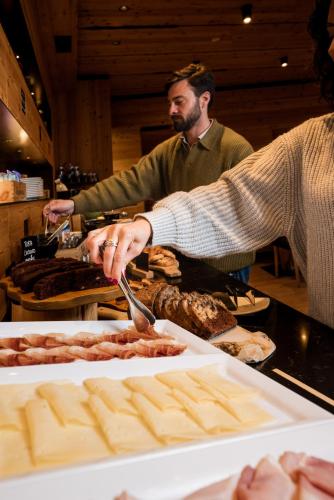 a person is preparing food at a buffet at Hotel Li Anta Rossa - Adults Only in Livigno