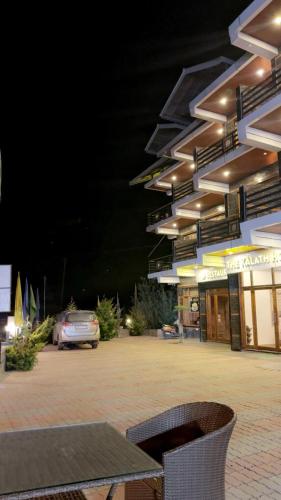 a building with a car parked in a parking lot at The Kalath House in Vashisht