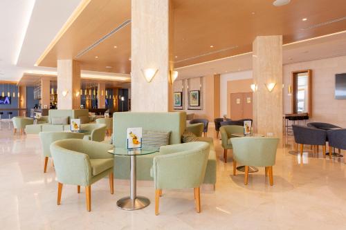 a restaurant with chairs and tables in a lobby at Hipotels Barrosa Park in Chiclana de la Frontera
