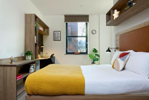 a bedroom with a bed and a desk and a window at For Students Only - Student Castle Reading in Reading