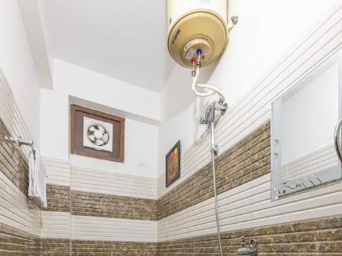 a bathroom with a shower with a light on the ceiling at The Heritage Village Kasauli by Splendid Hotels in Kasauli