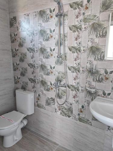 a bathroom with a toilet and a sink at Svetla Guest House in Primorsko