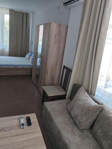 a living room with a couch and a bed at Svetla Guest House in Primorsko