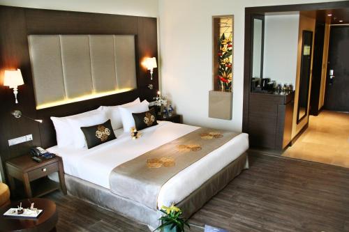 a bedroom with a large bed in a hotel room at Radisson Blu Plaza Hotel Mysore in Mysore