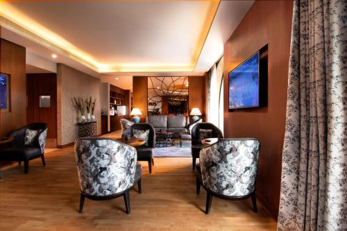 a living room with chairs and a table at Radisson Blu Plaza Hotel Mysore in Mysore