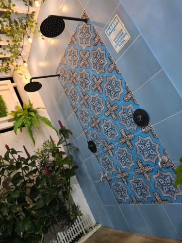 a surfboard on a wall with blue tiles at Casa Amoris Uno in Los Baños