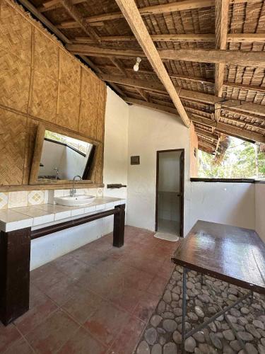 a large bathroom with a sink and a mirror at Labros Adventure Camp and Waterfront in Calintaan