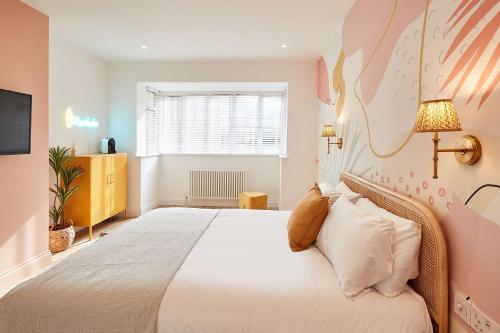a bedroom with a large white bed and a window at Beach House in Scarborough