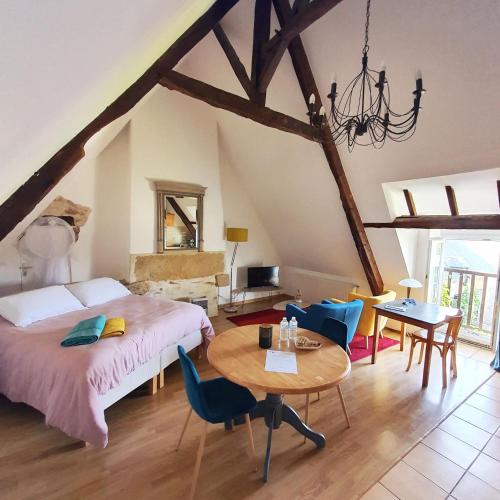 une chambre avec un lit, une table et des chaises dans l'établissement La Vallée du Launay, à Taden