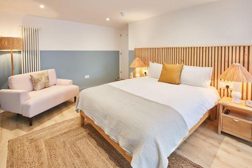 a bedroom with a large bed and a chair at The Beach House - Pool & Spa in Scarborough