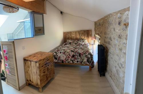 a bedroom with a bed and a stone wall at L'escalette in Vernoux-en-Vivarais