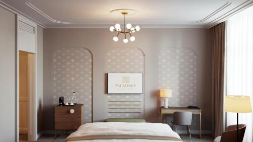 a bedroom with a bed and a table and a chandelier at Palatinus Grand Hotel in Pécs
