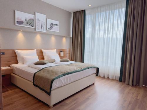 a bedroom with a bed and a large window at Hotel Via Vitez in Vitez