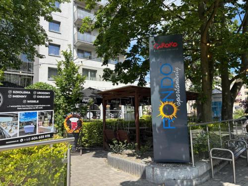 a sign in a park next to a building at Apartamenty Rondo in Świnoujście