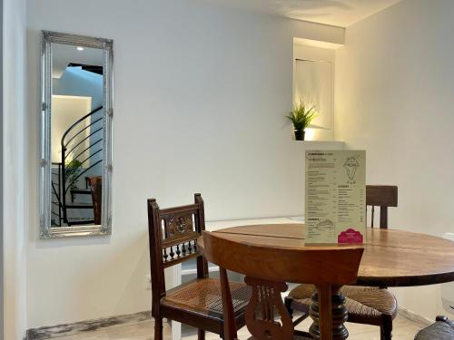 une salle à manger avec une table, des chaises et un miroir dans l'établissement Croissant de Lune - Cœur de Ville - Old Town, à Bayeux