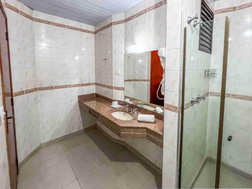 a bathroom with a sink and a shower at Hotel Nacional Inn Campos do Jordão in Campos do Jordão