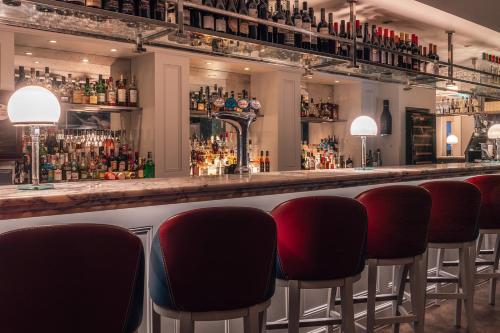 a bar with a row of red chairs at Harbour Hotel & Spa Brighton in Brighton & Hove