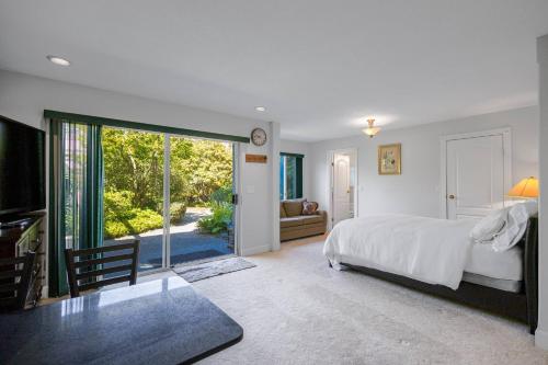 a bedroom with a bed and a sliding glass door at Garden Suite near Jericho Beach in Vancouver