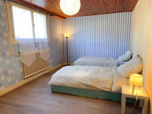 a bedroom with a bed and a lamp and a window at 住在巴黎 in Bondy