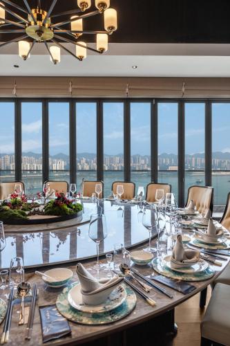 a dining room with a long table with a view at Chongqing Jiayu Emperor Hotel in Jiulongpo