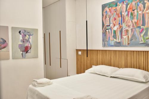 una camera da letto con un letto e quadri sul muro di Wavefront Apartment 3 a Vlorë