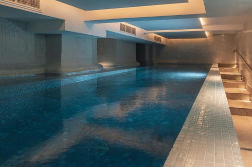 a swimming pool with blue water in a building at Harbour Hotel & Spa Brighton in Brighton & Hove
