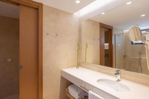 a bathroom with a sink and a mirror at Hipotels Barrosa Park in Chiclana de la Frontera