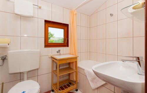 a bathroom with a toilet and a sink at Villa Ivka-Omis by Villas Guide in Katuni
