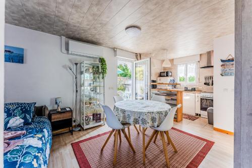 une cuisine et un salon avec une table et des chaises dans l'établissement Henriela - Studio 2 personnes, à Gujan-Mestras