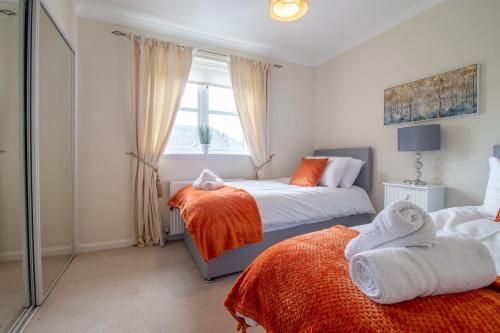 a bedroom with two beds and a window at The Well - 3 bedroom apartment in Motherwell