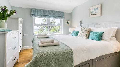 Un dormitorio con una cama grande y una ventana. en Fron Olau, en Nefyn