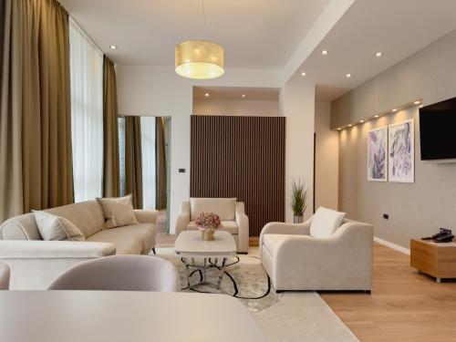 a living room with couches and chairs and a television at Hotel Via Vitez in Vitez